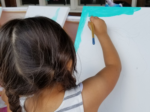 Young girl painting a picture.