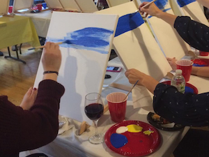 Group of artists painting on canvases.