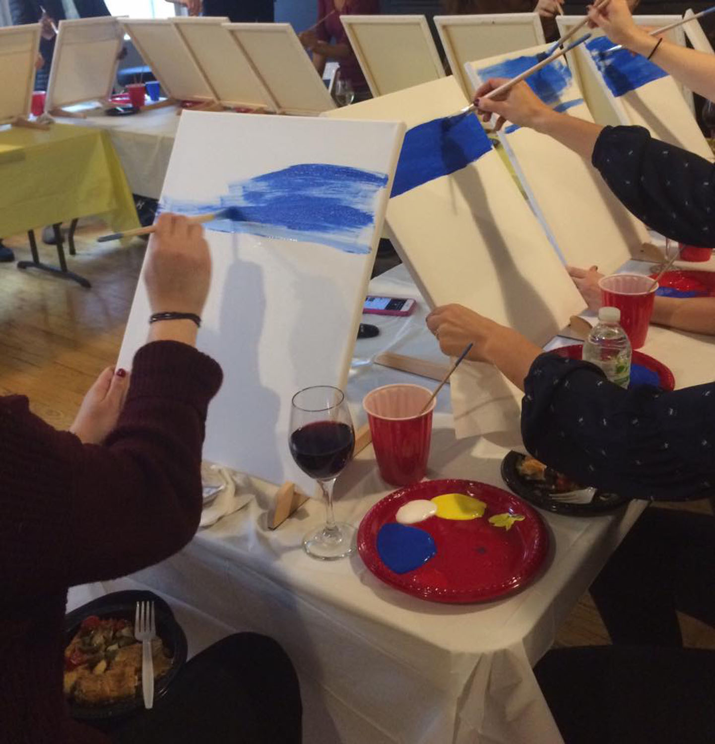 Group of artists painting on canvases.