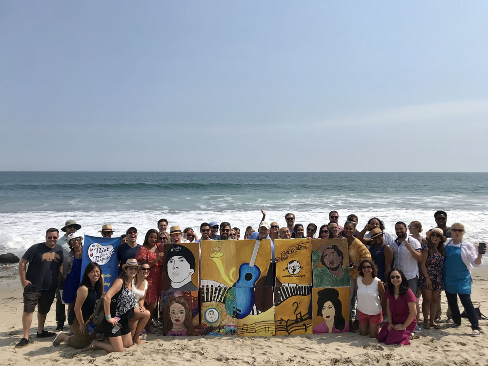 Paint for a Purpose Team Building Event, large group of adults standing in front of the ocean.